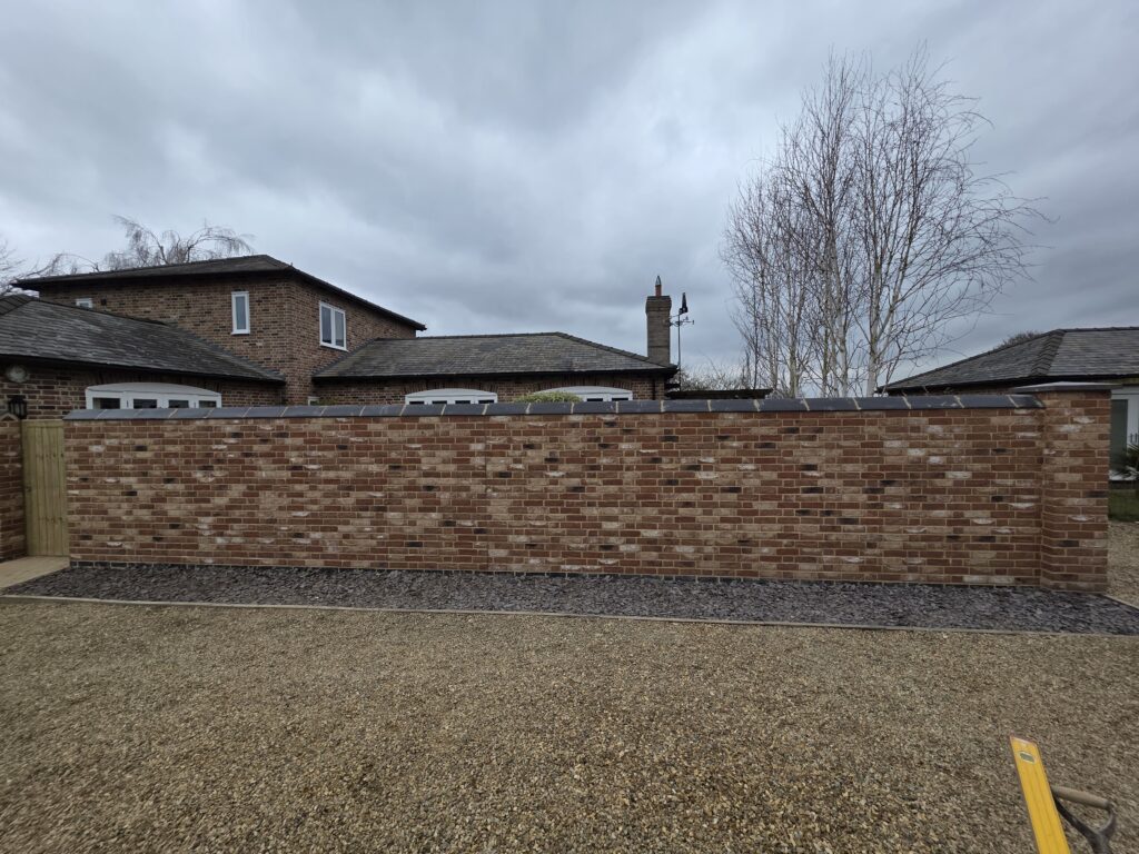A newly built multi-toned brick wall with dark grey