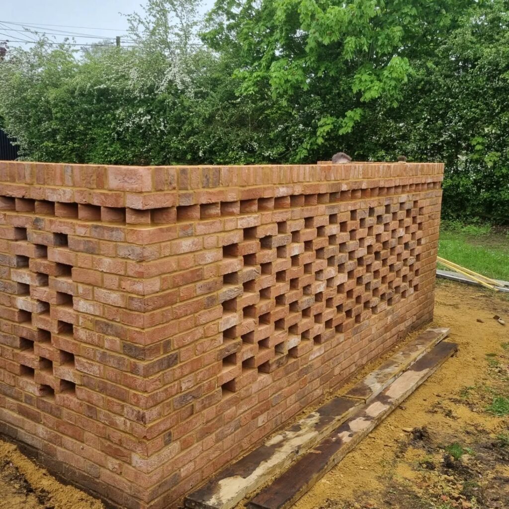 A corner brick wall with an openwork pattern of staggered bricks, set